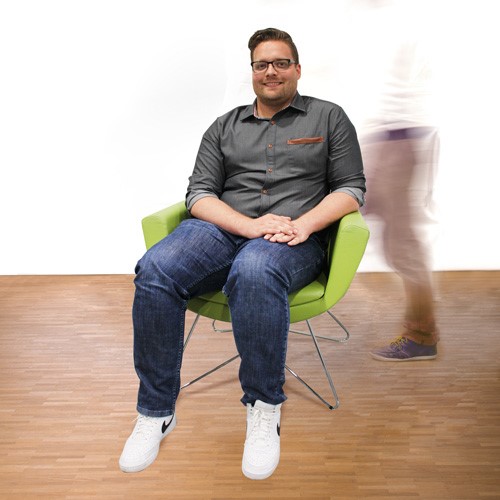 Mitarbeiter Markus sitzt auf dem grünen Stuhl