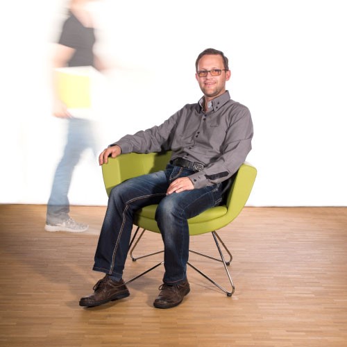 Mitarbeiter Horst sitzt auf dem grünen Stuhl
