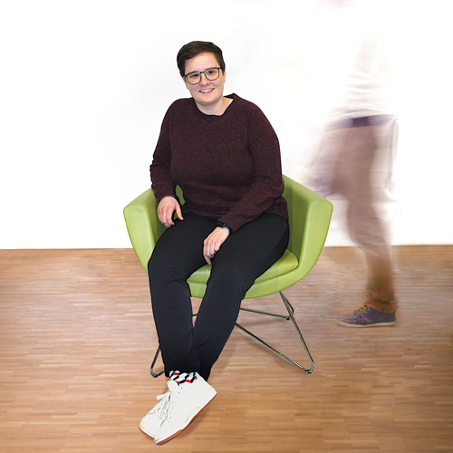 Mitarbeiterin Katharina sitzt auf dem grünen Stuhl